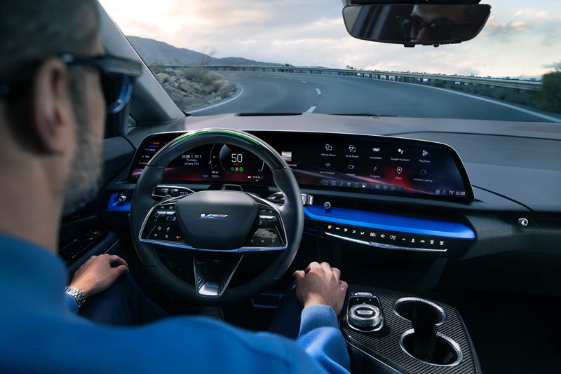 Front View of the 2026 OPTIQ-V Driving Through the Dusk Utilizing its Headlights | Durand Cadillac in Leominster MA